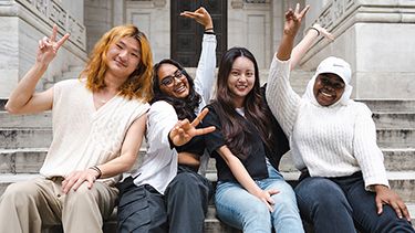 Students making victory sign outside in the campus