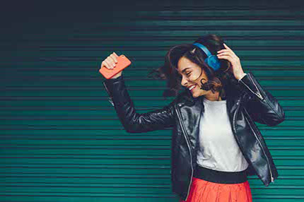 Female student wearing headphone and dancing
