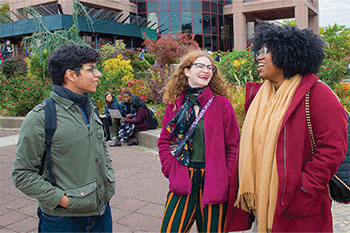 Three students talking outside in the campus