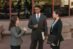Students are standing and talking outside in the campus