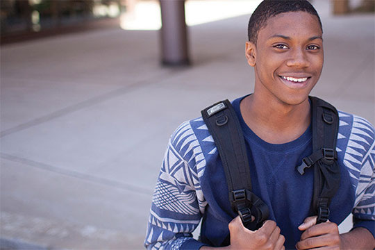 A male student smiling in front of camera