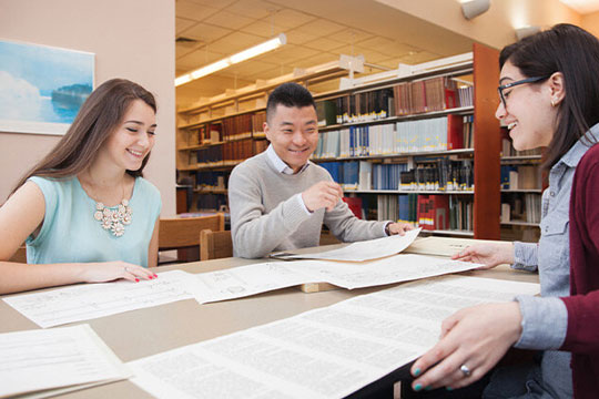 Student reading notes in the college library