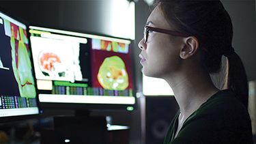 A female student watching on the computer screen in the lab