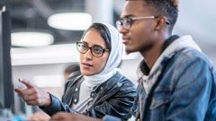 Two students watching on the desktop screen